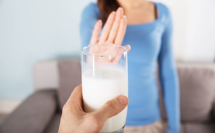 A woman saying no to a glass of milk